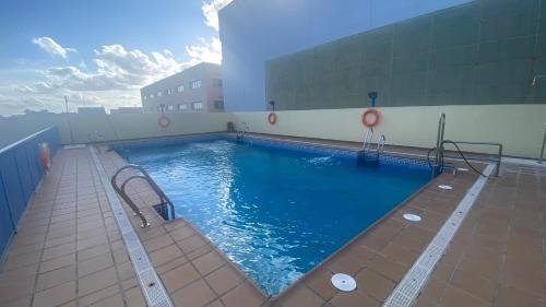 una gran piscina al lado de un edificio en LuxSevilla Moderno 1 Room Piscina Parking en Bormujos
