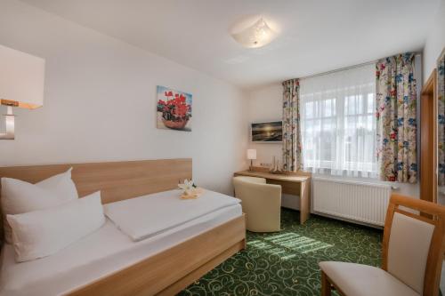 una camera d'albergo con letto e scrivania di Gasthaus & Pension Natzke a Usedom Town