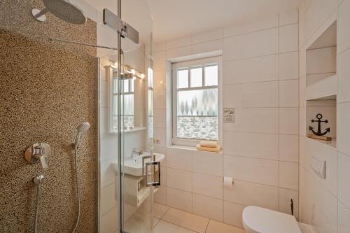 e bagno con doccia, servizi igienici e lavandino. di Gasthaus & Pension Natzke a Usedom Town
