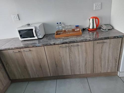 a kitchen with a counter top with a microwave at City Centre Hotel in Walvis Bay