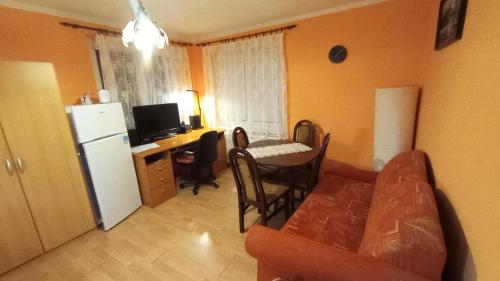 a living room with a couch a table and a refrigerator at HannaH - Relax dom pod orechom Apartman2 in Trávnica