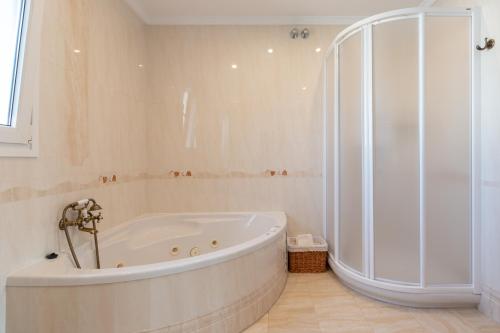 ein weißes Bad mit einer Badewanne und einer Dusche in der Unterkunft La casita del Mar in Torremolinos