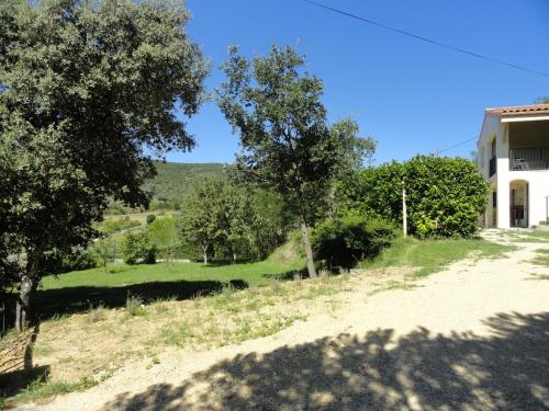 un chemin de terre à côté d'une maison et d'arbres dans l'établissement Les Lauriers roses Vallon Pont d'Arc, à Lagorce