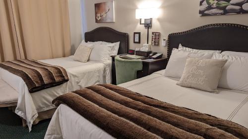 um quarto de hotel com duas camas com um cobertor em Amherst Inn - Virginia em Amherst