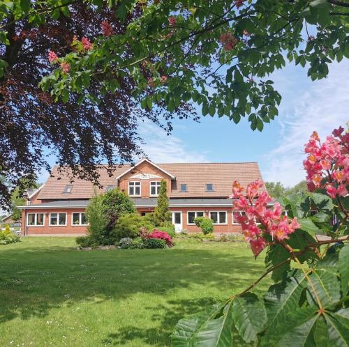a large house with a yard with flowers at Mikkelborg Kro in Rødding