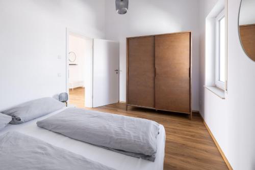 a white bedroom with a bed and a closet at Ferienwohnung Hendriks in Nonnenhorn