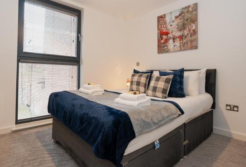 1 dormitorio con 1 cama grande con sábanas azules en Smart & modern Chester city-centre flat - Sleeps 2 en Chester