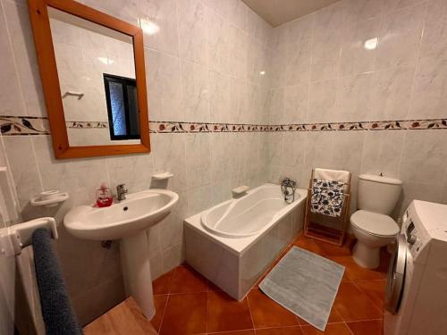 een badkamer met een wastafel, een bad en een toilet bij Spacious Apartment in Marsalforn close to Seafront in Marsalforn
