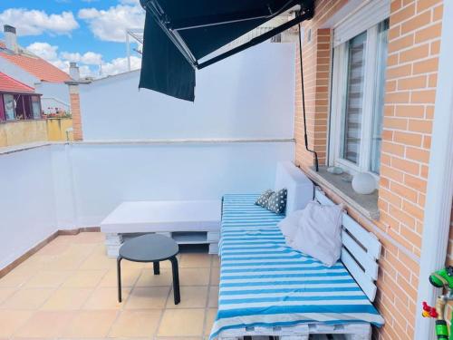 un pequeño balcón con banco y ventana en Precioso ático con garaje gratis en Salamanca