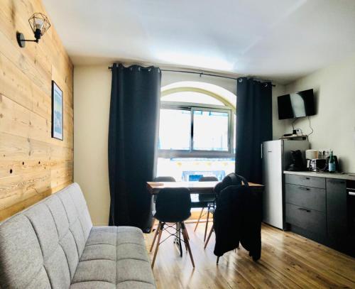 un salon avec un canapé et une table avec des chaises dans l'établissement Lou Bigourdan, à Cauterets