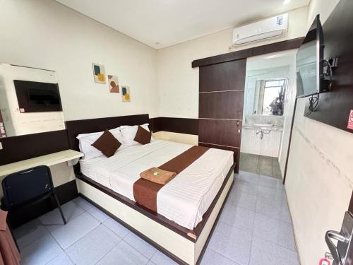 um quarto com uma cama grande e uma casa de banho em FAKHIRA RESIDENCE HOTEL em Cianjur