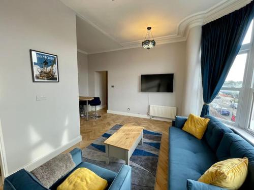 a living room with a blue couch and a table at Newly Refurbished 1 Bed Flat Southsea in Portsmouth