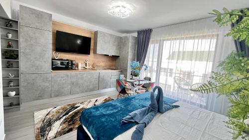 ein Wohnzimmer mit einem Bett und einer Küche in der Unterkunft Cosmopolitan - Studio pe plaja cu vedere la mare & loc parcare gratis in Mamaia Nord – Năvodari