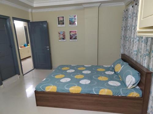 a bedroom with a bed with a blue and yellow comforter at Penthouse RK Beach in Visakhapatnam