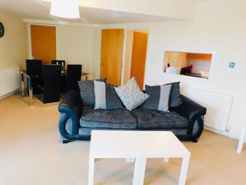 a living room with a couch and a white table at No 2 - Modern 2 Bed Apartment Close to Gla Airport & M8 in Paisley
