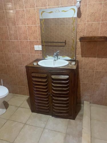 ein Bad mit einem Waschbecken und einem Spiegel in der Unterkunft One bedroom holiday home malindi in Malindi