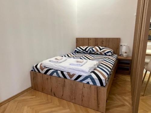 a bedroom with a wooden bed with two towels on it at Rio Studio by Sienna in Skopje