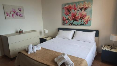 um quarto com uma cama e um quadro na parede em Corte dei Fiori Acquaviva Apartments em Marittima