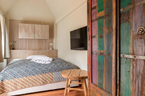 Schlafzimmer mit einem Bett und einer Holztür in der Unterkunft Dat Lütthus in Ahrenshoop