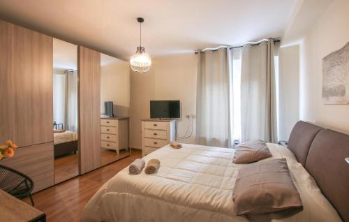 a bedroom with a large bed and a television at 3 Bedroom Nice Apartment In Rovereto in Rovereto