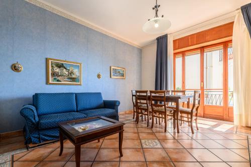 een woonkamer met een blauwe bank en een tafel bij Maiori Apartment with terrace and sea view in Maiori