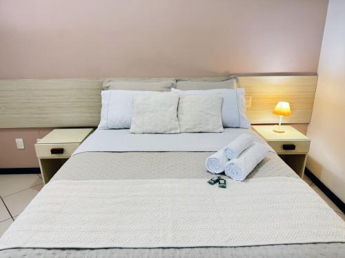 um quarto com uma cama grande e toalhas em Flat Exclusivo no Crystal Apart Hotel! em Macaé