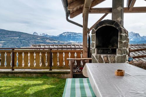 a stone fireplace on a patio with mountains in the background at Malsötscherhof Apt A in Villandro