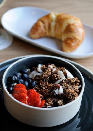 a bowl of food on a plate with fruit and a croissant at Czakó Bed&Breakfast in Budapest