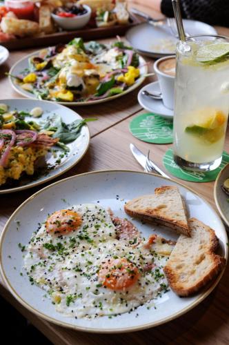 a table with plates of food and a drink at Czakó Bed&Breakfast in Budapest