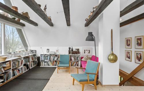 een woonkamer met 2 stoelen en boekenplanken bij Lovely Home In Mern With Wifi in Mern