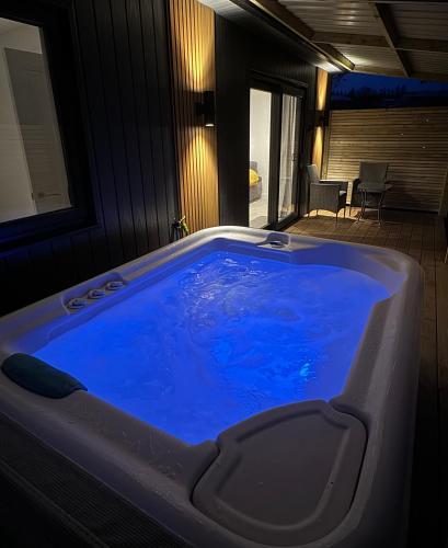 a large blue tub in a room with a patio at Glenariff Forest Redwood Lodge in Glenariff