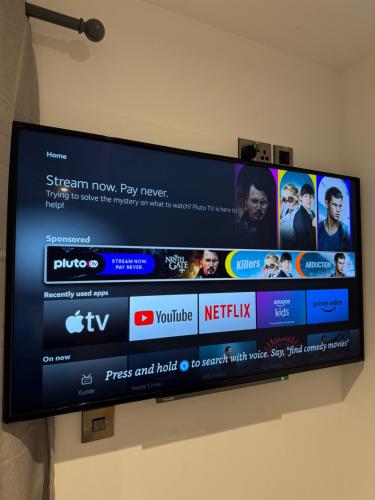 a flat screen tv hanging on a wall at Glenariff Forest Redwood Lodge in Glenariff