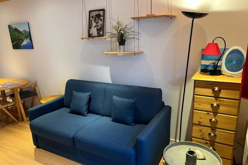 - un canapé bleu avec deux oreillers dans le salon dans l'établissement Modern Apt With View On The Aiguille Du Midi, à Chamonix-Mont-Blanc