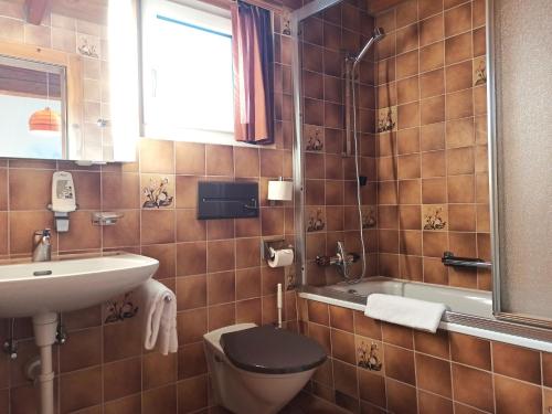 La salle de bains est pourvue de toilettes, d'un lavabo et d'une baignoire. dans l'établissement Hotel Acla Filli, à Zernez