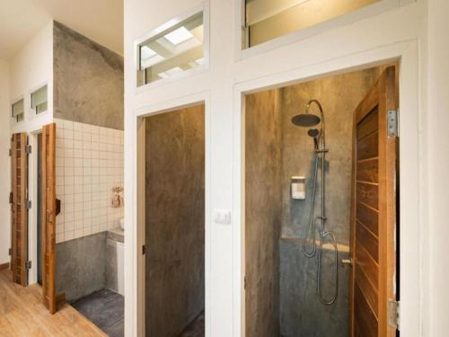 uma casa de banho com um chuveiro e uma porta de vidro em OYO 75471 Better Zzz em Bangkok