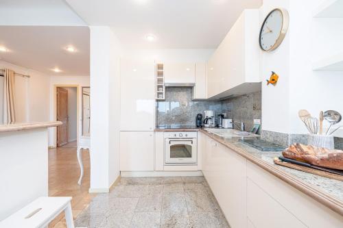 une cuisine avec des placards blancs et un comptoir dans l'établissement Le Soleil d'Antibes - Happy Rentals, à Antibes