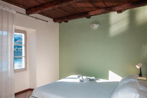 a bedroom with a white bed and a window at -Ortaflats- Appartamento l'Isola in Orta San Giulio