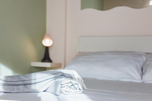 a bed with a blanket on it next to a lamp at -Ortaflats- Appartamento l'Isola in Orta San Giulio