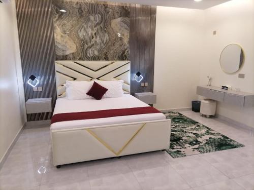 a bedroom with a large bed and a mirror at MY HOTEL AL YAQOT 3 POOLS VILLA - NIZWA in Nizwa