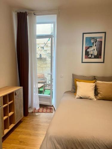 une chambre avec un lit et une grande fenêtre dans l'établissement Le Laurier-rose, à Montpellier