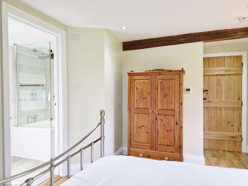 1 dormitorio con 1 cama y puerta de madera en Sussex Barns - Horsham en Horsham