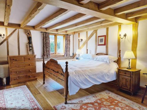 a bedroom with a bed and a wooden ceiling at Sussex Barns - Horsham in Horsham