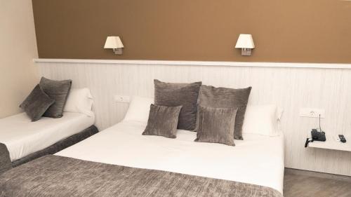 a bedroom with two beds with pillows on them at Hotel Coronado in Barcelona