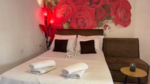 a bedroom with a bed with red roses on the wall at SWEET apartment near Old Town in Mostar
