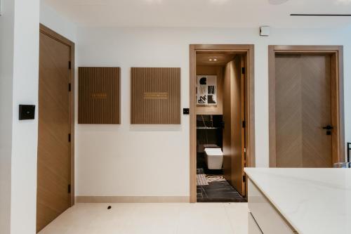 a bathroom with a toilet and a white wall at Cozy 1 Bedroom in the heart of Business Bay in Dubai