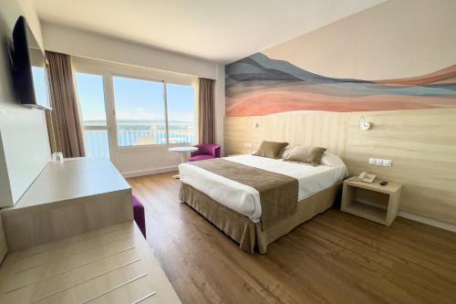 マガルフにあるBahia Principe Sunlight Coral Playaのベッド付きの客室で、壁には絵画が飾られています。