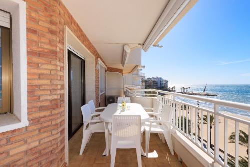a balcony with a table and chairs and the ocean at UHC SANTILLANA FAMILY COMPLEX in Salou