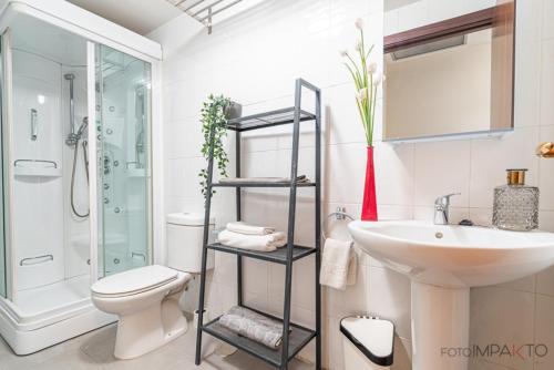 a bathroom with a white toilet and a sink at Apartamento en Vista Alegre in Madrid
