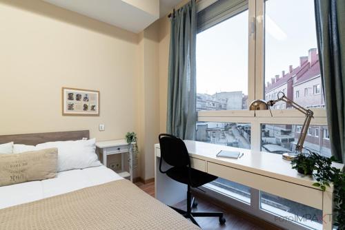 a bedroom with a desk and a bed and a window at Apartamento en Vista Alegre in Madrid