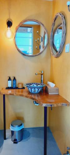 a bathroom with a sink and two mirrors at Monte da Urze Aljezur in Aljezur